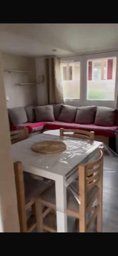 un salon avec une table et un canapé dans l'établissement MH 477 CASITA 3 chambres 1 salle de bain dans camping 4 étoiles avec parc aquatique, à Saint-Julien-en-Born