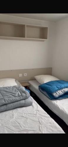 deux lits côte à côte dans une pièce dans l'établissement MH 477 CASITA 3 chambres 1 salle de bain dans camping 4 étoiles avec parc aquatique, à Saint-Julien-en-Born
