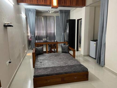 a bedroom with a bed and a table in it at A4, Melam, Hima Havens- 200 m from Guruvayoor Temple in Guruvāyūr