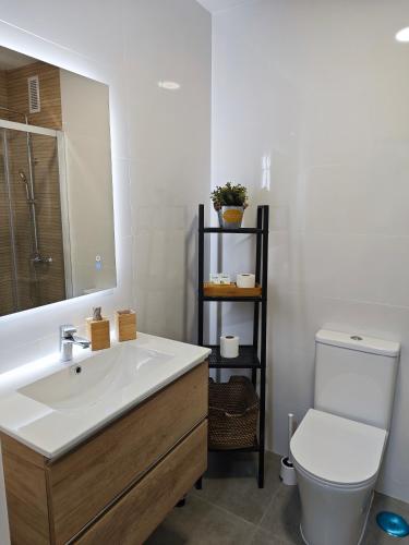a bathroom with a sink and a toilet and a mirror at EL ESTUDIO DE LA PLAYA Sunny Holidays Benalbeach in Benalmádena