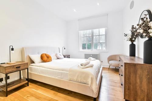 a white bedroom with a bed and a desk at Wonderful Fitzrovia 3 Bed Apartment in London