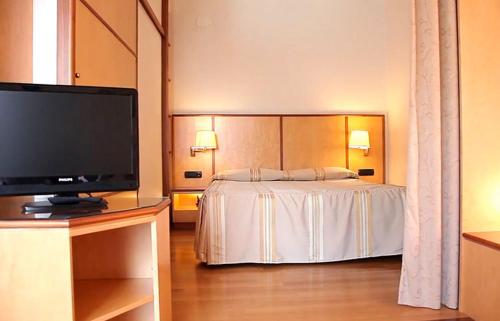 a hotel room with a bed and a flat screen tv at Pràti Home in Rome