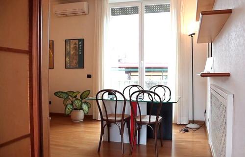 a dining room with a table and chairs and a window at Pràti Home in Rome