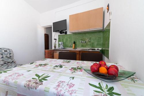 a bowl of fruit on a table in a kitchen at Apartments Din in Kukljica