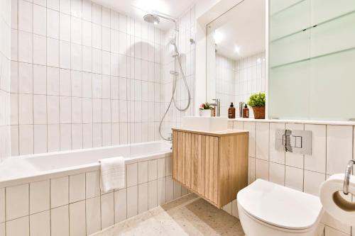 a bathroom with a tub and a toilet and a sink at Wonderful Fitzrovia 3 Bed Apartment in London