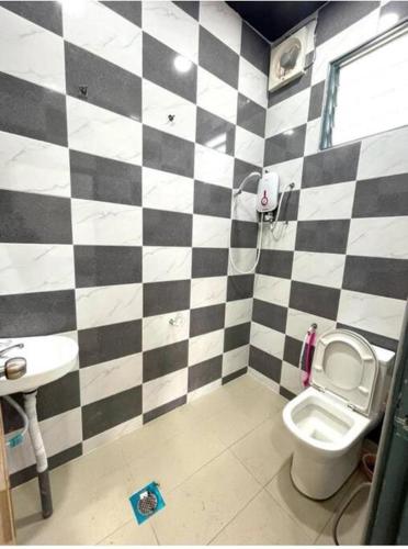 a black and white checkered bathroom with a toilet and sink at RALI PD HOME D 16Pax karaoke and swimming pool in Port Dickson