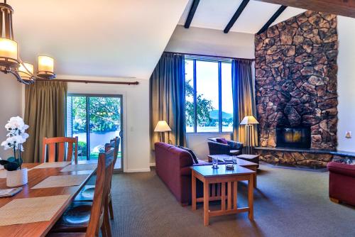 a dining room and living room with a table and a fireplace at Lake Placid Club Lodges in Lake Placid