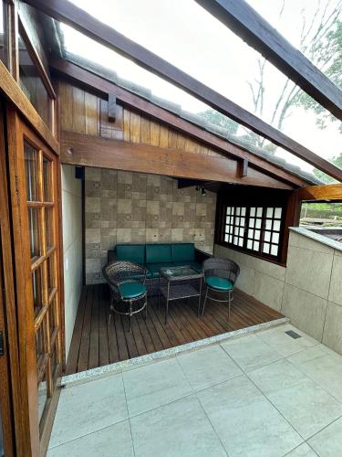 a patio with a table and chairs on a deck at Gaia Hotelaria in Teresópolis