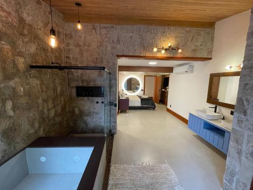 a large bathroom with a tub and a sink at Gaia Hotelaria in Teresópolis
