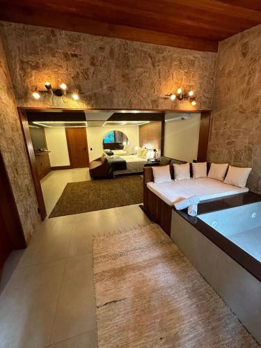 a bedroom with a large bed and a bath tub at Gaia Hotelaria in Teresópolis