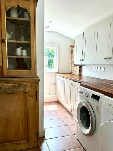 a kitchen with a washing machine in a kitchen at Perfect country cottage retreat! in Fyfield