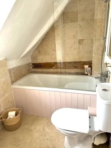 a bathroom with a toilet and a bath tub at Perfect country cottage retreat! in Fyfield