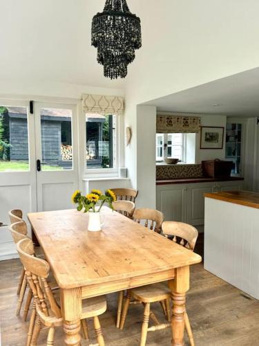 a dining room with a wooden table and chairs at Perfect country cottage retreat! in Fyfield