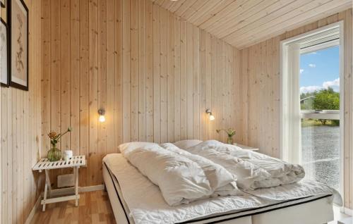 a bedroom with a bed with white sheets and a window at Gorgeous Home In Fjerritslev With Sauna in Fjerritslev