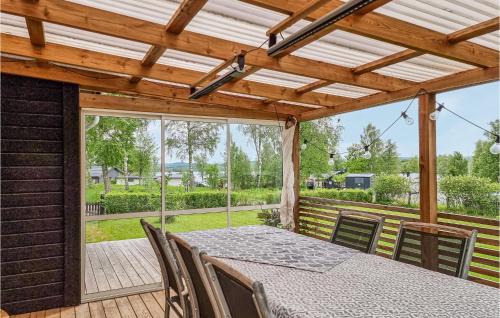 a dining room with a table and chairs on a deck at Gorgeous Home In Hökerum With Lake View in Hökerum