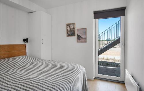 a bedroom with a bed and a large sliding glass door at Havnehusene, Lejl 37 in Engvang