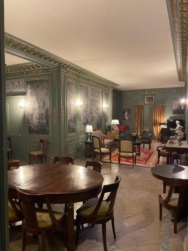 Cette chambre est dotée de murs verts, de tables et de chaises. dans l'établissement Appartement dans château, à Limay