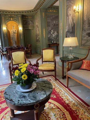 un salon avec un vase de fleurs sur une table dans l'établissement Appartement dans château, à Limay