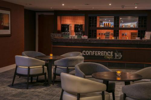 a restaurant with tables and chairs and a bar at The Telford Hotel, Spa & Golf Resort in Telford