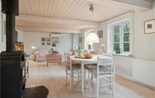 a kitchen and living room with a table and chairs at 3 Bedroom Lovely Home In Østermarie in Østermarie