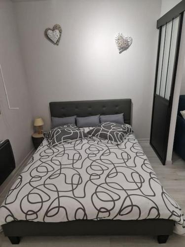 - une chambre avec un lit et deux cœurs sur le mur dans l'établissement Appartement Au petit bonheur, à Faimbe