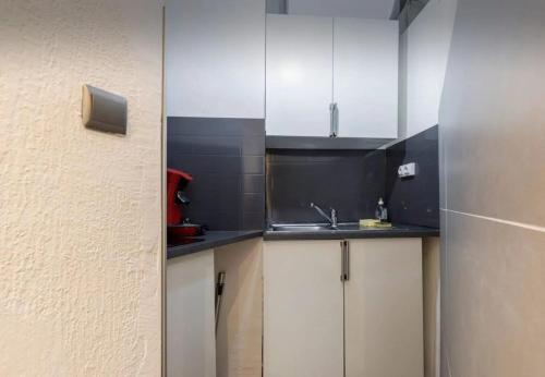 une cuisine avec des armoires blanches et un évier dans l'établissement Studio confortable à Nice - 19 m² avec vue sur la ville, à Nice