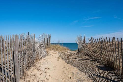 a fence on the beach next to the ocean at OBX 4BR Oceanfront Cottage in Kill Devil Hills