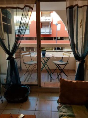 Cette chambre offre une vue sur une terrasse dotée d'une table et de chaises. dans l'établissement Le quai de bosc, à Sète