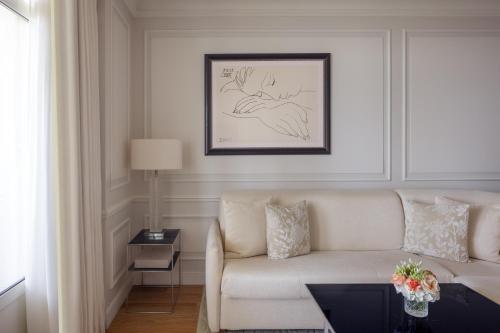a living room with a white couch and a table at Grand-Hôtel du Cap-Ferrat, A Four Seasons Hotel in Saint-Jean-Cap-Ferrat