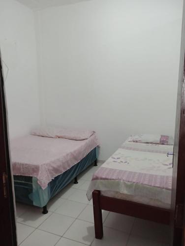 two beds sitting next to each other in a room at Casa pousada Milton in Angra dos Reis