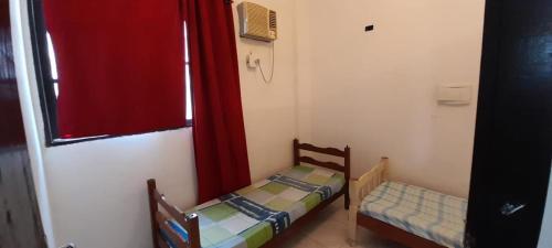 a small room with two beds and a window at Casa pousada Milton in Angra dos Reis