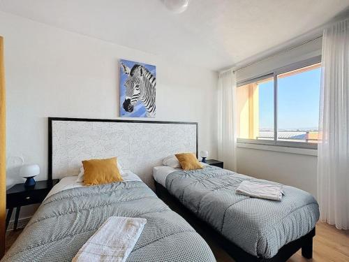 une chambre avec deux lits et une grande fenêtre dans l'établissement Le quai 52 - Spacieux & Lumineux & Gare SNCF Albert Elisabeth B, à Clermont-Ferrand