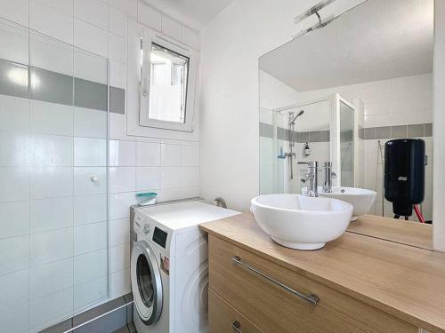 une salle de bain avec un lavabo et une machine à laver dans l'établissement Le quai 52 - Spacieux & Lumineux & Gare SNCF Albert Elisabeth B, à Clermont-Ferrand