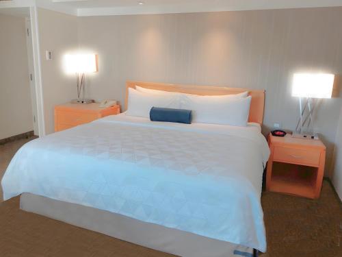 a bedroom with a large bed with two night stands at Holiday Inn Cuernavaca by IHG in Cuernavaca