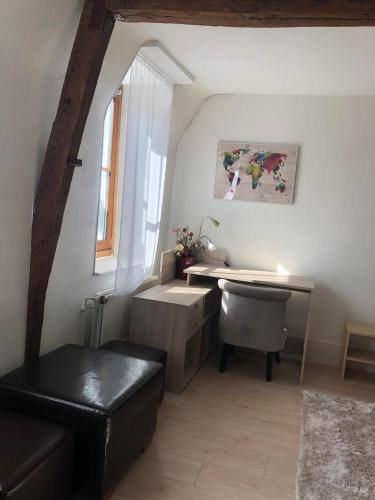 Cette chambre dispose d'un bureau, d'une chaise et d'une fenêtre. dans l'établissement Maison arrageoise authentique, entre ville et parc, à Arras