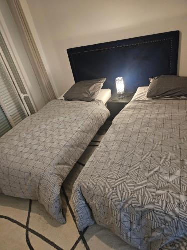 two beds sitting next to each other in a bedroom at Emmanuel INN 1 in Drancy