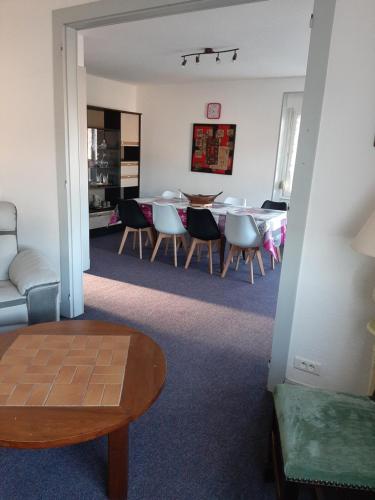 un salon avec une table et des chaises dans l'établissement F6 2e étage 4 chambres Gerardmer Centre, à Gérardmer