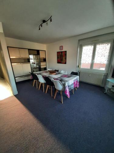 une salle à manger avec une table et des chaises dans une pièce dans l'établissement F6 2e étage 4 chambres Gerardmer Centre, à Gérardmer