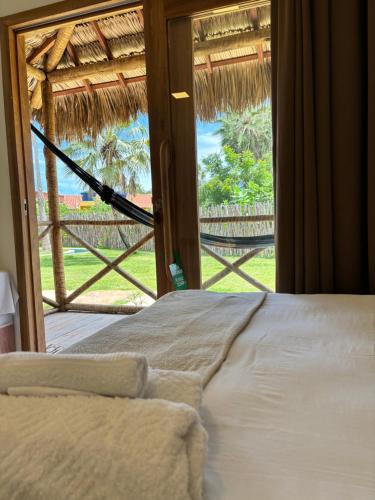 a bedroom with a bed and a large window at Pousada Vila Tapera in Barra Grande