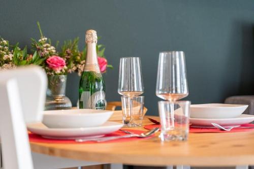 a table with a bottle of champagne and plates and glasses at Ferienwohnung-Zwischen-den-Seen in Rechlin