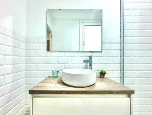 Un baño blanco con lavabo y espejo. en Olivo, en Ferrol
