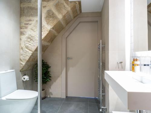 a bathroom with a toilet and a glass shower door at Arran Shores Luxury Shorefront Apartment 14 in Lamlash