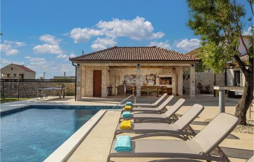 a row of lounge chairs next to a swimming pool at Villa Tany in Dračan