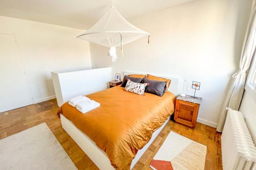 une chambre avec un lit avec un couvre-lit orange dans l'établissement Rooftop VIEW - Elevator - Hypercenter, à Avignon