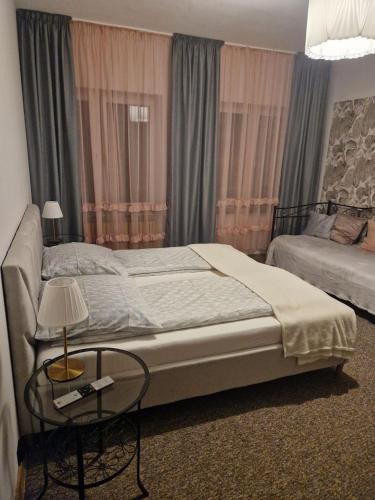 a bedroom with a bed and a table with a lamp at Pensjonat Galicja in Józefów