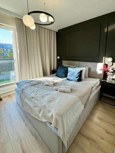 a bedroom with a large bed with towels on it at Wings&Dreams Apartments - Atlas Arena, ZOO, lotnisko, parking, winda, balkon in Łódź