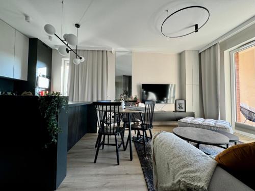 a living room with a table and chairs at Wings&Dreams Apartments - Atlas Arena, ZOO, lotnisko, parking, winda, balkon in Łódź