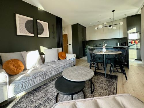 a living room with a white couch and a table at Wings&Dreams Apartments - Atlas Arena, ZOO, lotnisko, parking, winda, balkon in Łódź