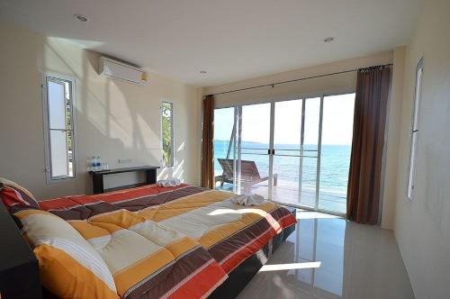 Ao Pong Resort في كو ماك: غرفة نوم بسرير كبير مطلة على المحيط