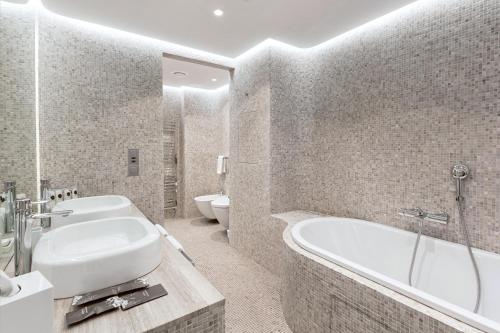 a bathroom with a tub, sink, and toilet at StandArt Hotel Moscow in Moscow